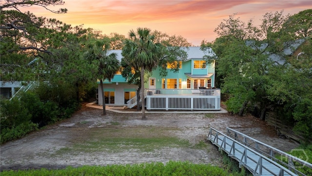 108 San Marco Dr, Tybee Island, GA 31328 - back of property at dusk featuring a porch and stucco siding