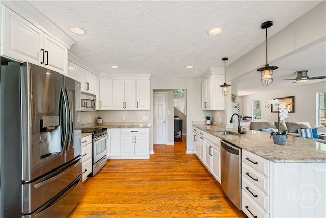 108 San Marco Dr, Tybee Island, GA 31328 - kitchen with appliances with stainless steel finishes, a sink, a peninsula, white cabinets, and a textured ceiling