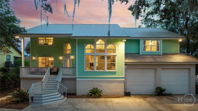 108 San Marco Dr, Tybee Island, GA 31328 - beach home with covered porch, stairway, metal roof, driveway, and a garage