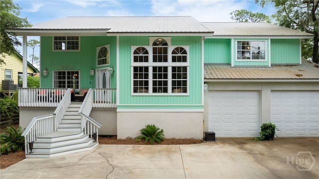 108 San Marco Dr, Tybee Island, GA 31328 - view of front of home featuring covered porch, stairway, metal roof, driveway, and an attached garage