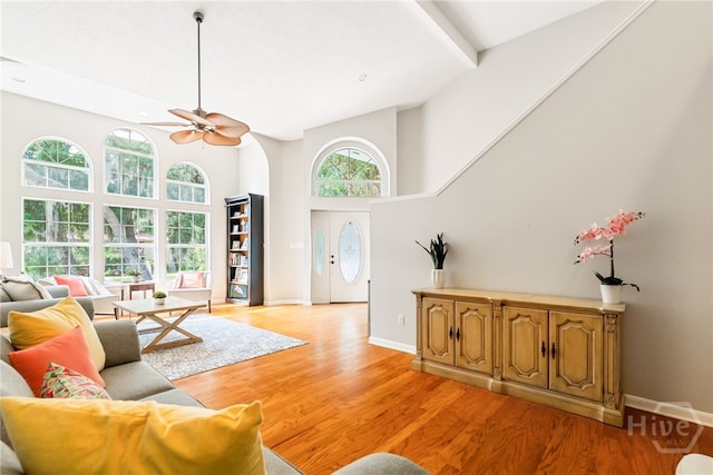 108 San Marco Dr, Tybee Island, GA 31328 - living room with high vaulted ceiling, a ceiling fan, light wood-style floors, and baseboards