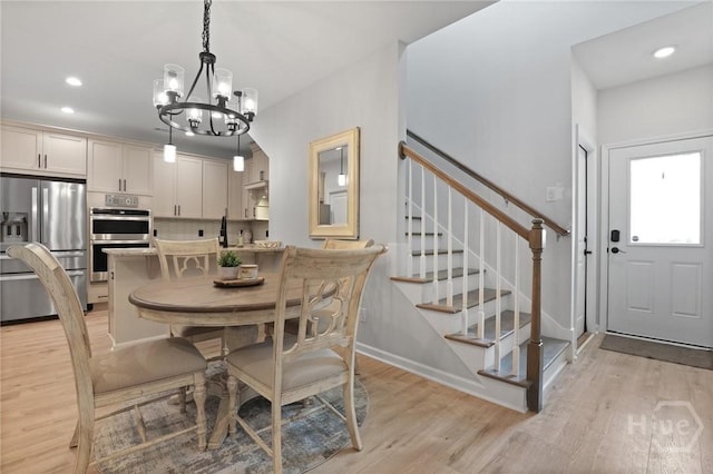 73 Small Pine Ln, Richmond Hill, GA 31324 - dining room featuring a chandelier, light wood-style floors, recessed lighting, stairway, and baseboards