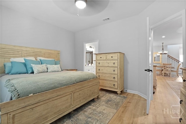 73 Small Pine Ln, Richmond Hill, GA 31324 - bedroom with a chandelier, wood finished floors, connected bathroom, baseboards, and a ceiling fan