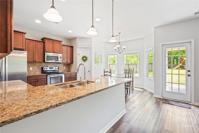 821 NE Mustang Ln, Ludowici, GA 31316 - kitchen with appliances with stainless steel finishes, a sink, brown cabinetry, plenty of natural light, and recessed lighting