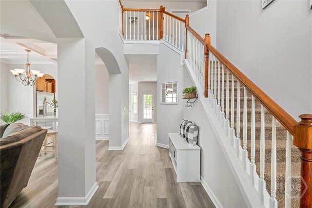 821 NE Mustang Ln, Ludowici, GA 31316 - entryway featuring arched walkways, light wood-style floors, a chandelier, and stairway