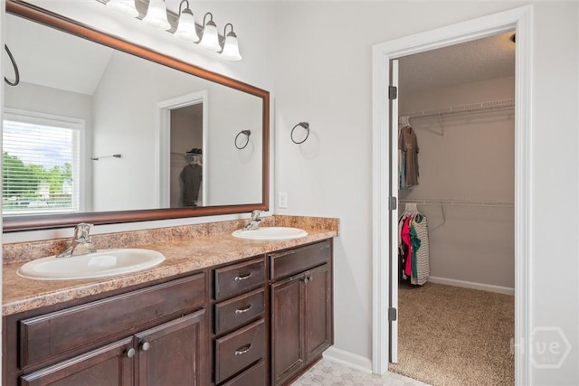 821 NE Mustang Ln, Ludowici, GA 31316 - bathroom featuring double vanity, a spacious closet, and vaulted ceiling