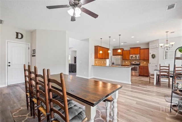 821 NE Mustang Ln, Ludowici, GA 31316 - dining space with arched walkways, ceiling fan, light wood-style flooring, a chandelier, and recessed lighting