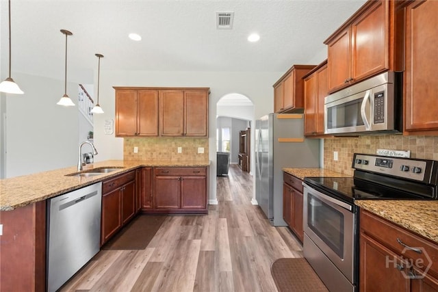 821 NE Mustang Ln, Ludowici, GA 31316 - kitchen featuring appliances with stainless steel finishes, a sink, arched walkways, light wood-style floors, and recessed lighting