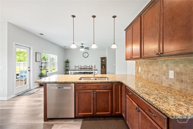 821 NE Mustang Ln, Ludowici, GA 31316 - kitchen featuring dishwasher, a peninsula, light wood-type flooring, decorative backsplash, and light stone countertops