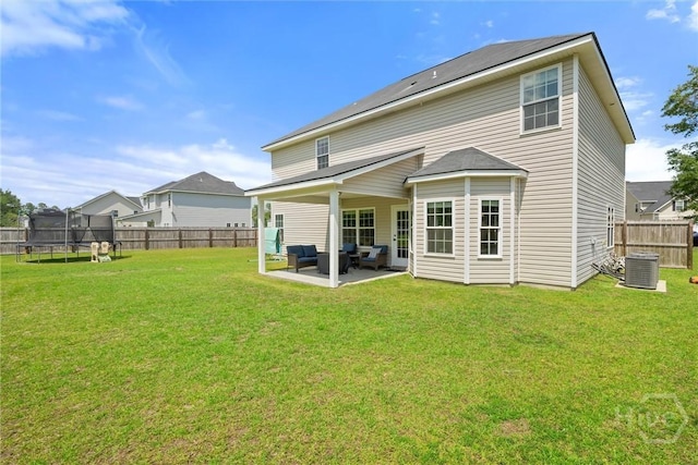 821 NE Mustang Ln, Ludowici, GA 31316 - back of property featuring a trampoline, outdoor lounge area, a patio area, and central air condition unit