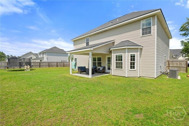 821 NE Mustang Ln, Ludowici, GA 31316 - rear view of property featuring a trampoline, an outdoor living space, a patio area, and a fenced backyard