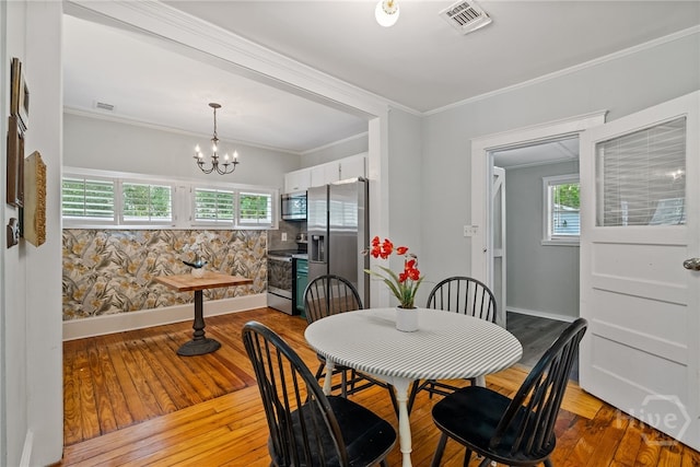 2609 Bismark Ave, Savannah, GA 31406 - dining room with wood-type flooring, plenty of natural light, baseboards, a chandelier, and crown molding