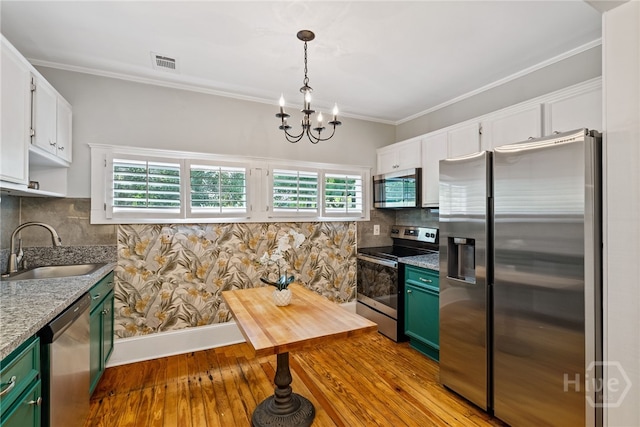 2609 Bismark Ave, Savannah, GA 31406 - kitchen with stainless steel appliances, green cabinets, a sink, a chandelier, and hardwood / wood-style flooring