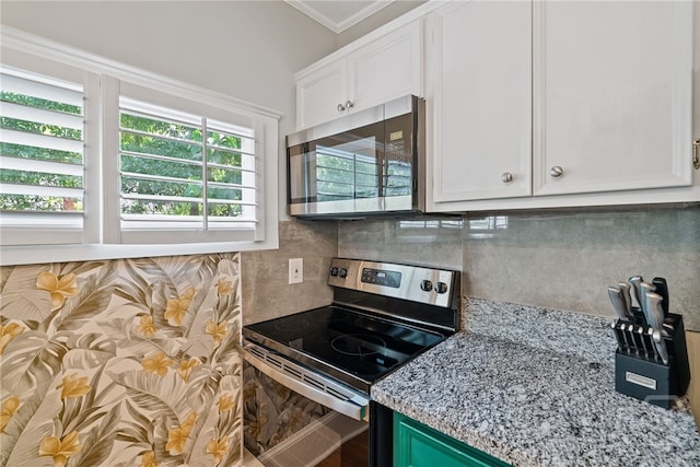 2609 Bismark Ave, Savannah, GA 31406 - kitchen featuring appliances with stainless steel finishes, white cabinets, tasteful backsplash, light stone counters, and crown molding