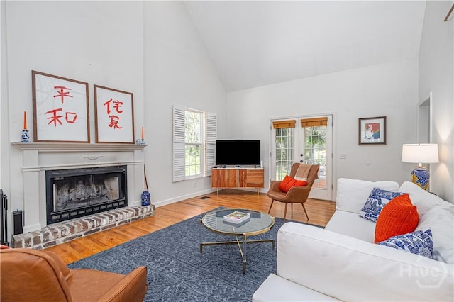 8720 Ferguson Ave, Savannah, GA 31406 - living room with high vaulted ceiling, wood finished floors, a brick fireplace, and baseboards