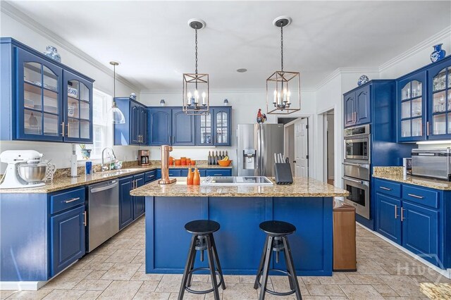 8720 Ferguson Ave, Savannah, GA 31406 - kitchen with stainless steel appliances, blue cabinetry, a kitchen island, a chandelier, and a kitchen bar