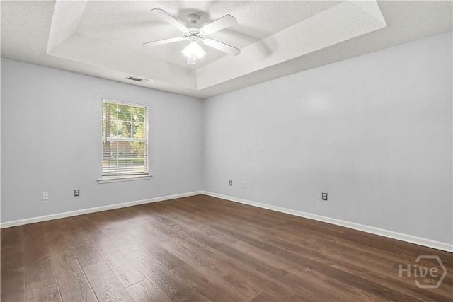 125 Crossing Cir, Rincon, GA 31326 - unfurnished room featuring a tray ceiling, dark wood-style floors, a ceiling fan, a textured ceiling, and baseboards