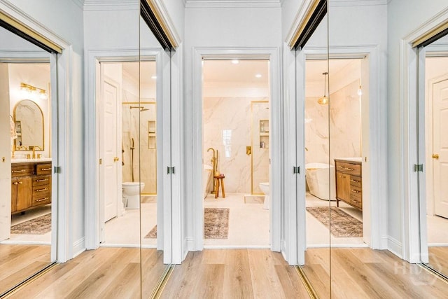 329 W Charlton St, Savannah, GA 31401 - hall featuring light wood-style flooring, ornamental molding, and a sink