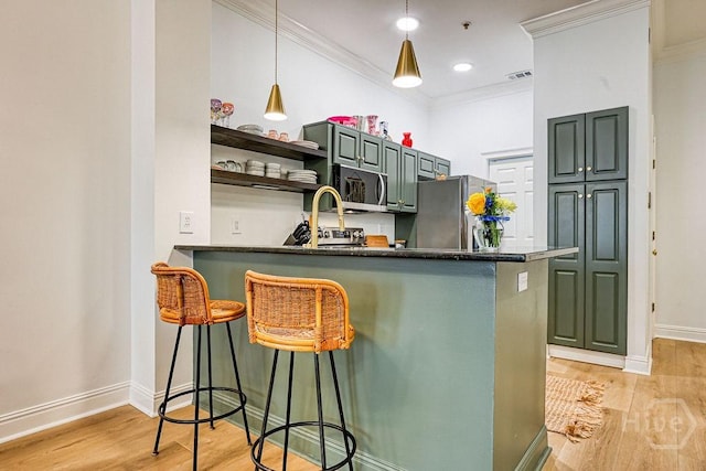 329 W Charlton St, Savannah, GA 31401 - kitchen with stainless steel appliances, crown molding, light wood-style flooring, baseboards, and a breakfast bar