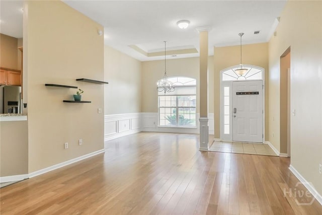 817 Granite Ln, Savannah, GA 31419 - entrance foyer featuring light wood-style floors, a chandelier, a raised ceiling, baseboards, and wainscoting