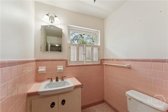 1525 Whitney Rd, Savannah, GA 31406 - bathroom with tile walls, vanity, a wainscoted wall, and toilet