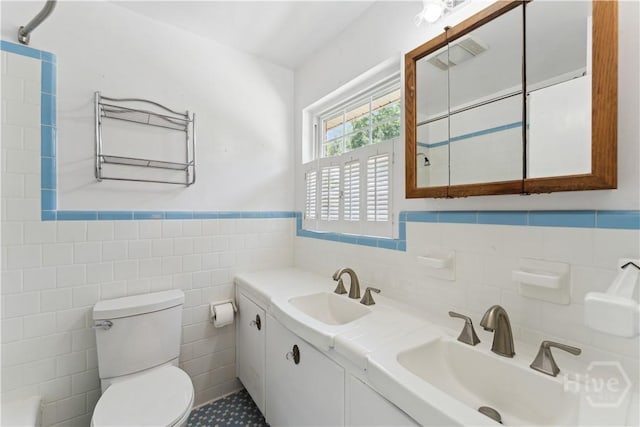 1525 Whitney Rd, Savannah, GA 31406 - full bathroom with tile walls, toilet, wainscoting, double vanity, and a shower