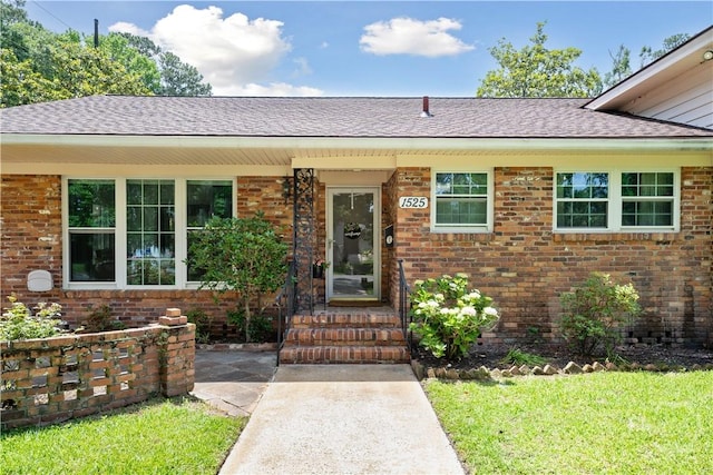 1525 Whitney Rd, Savannah, GA 31406 - property entrance featuring brick siding, roof with shingles, and a yard