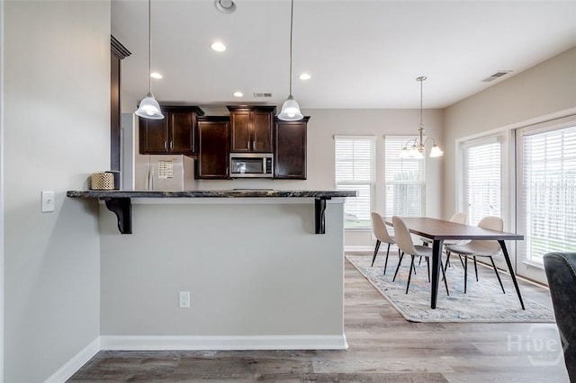 141 Lakepointe Dr, Savannah, GA 31407 - kitchen with stainless steel microwave, dark brown cabinetry, healthy amount of natural light, dark stone countertops, and recessed lighting