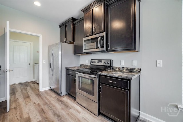 141 Lakepointe Dr, Savannah, GA 31407 - kitchen featuring appliances with stainless steel finishes, washer and clothes dryer, dark countertops, light wood-style flooring, and dark brown cabinetry