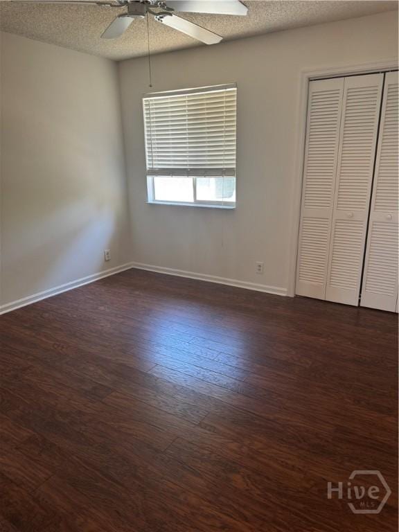 142 Bull River Bluff Dr, Savannah, GA 31410 - unfurnished bedroom with dark wood-type flooring, a textured ceiling, baseboards, a closet, and a ceiling fan