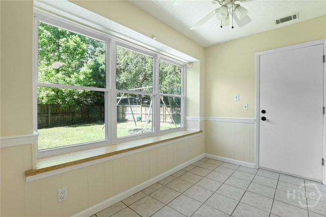 203 Whittington Dr, Savannah, GA 31419 - empty room featuring ceiling fan, light tile patterned floors, a wainscoted wall, and plenty of natural light