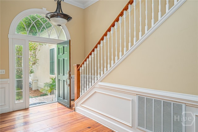 2 Franklin Creek Rd S, Savannah, GA 31411 - foyer entrance featuring stairs, a wainscoted wall, wood-type flooring, crown molding, and a decorative wall