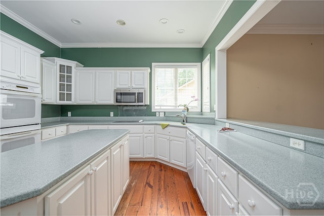 2 Franklin Creek Rd S, Savannah, GA 31411 - kitchen with white appliances, wood-type flooring, white cabinets, light countertops, and crown molding