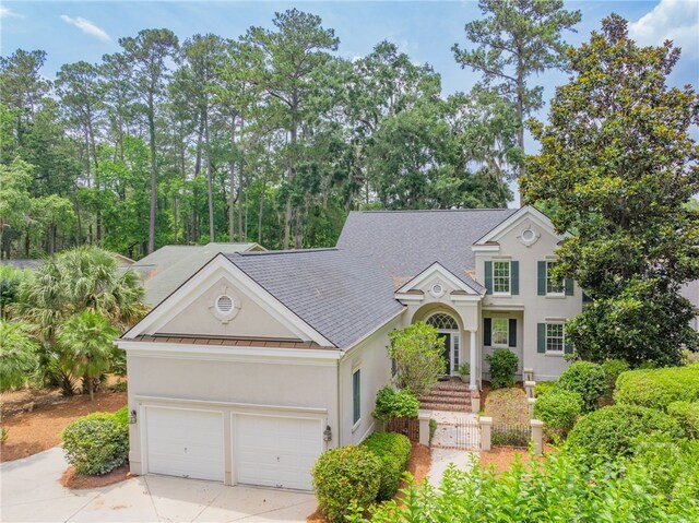 2 Franklin Creek Rd S, Savannah, GA 31411 - traditional-style house with stucco siding, a standing seam roof, concrete driveway, metal roof, and a garage
