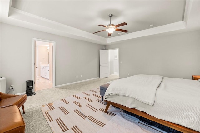 333 Waverly Ln, Richmond Hill, GA 31324 - bedroom with a tray ceiling, light colored carpet, baseboards, a ceiling fan, and ensuite bath