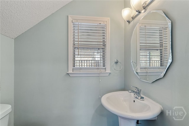 1406 Jones Ave, Tybee Island, GA 31328 - bathroom featuring plenty of natural light, a textured ceiling, and vaulted ceiling