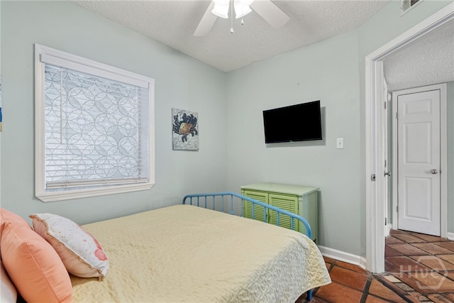 1406 Jones Ave, Tybee Island, GA 31328 - bedroom featuring a textured ceiling, multiple windows, tile patterned floors, and a ceiling fan