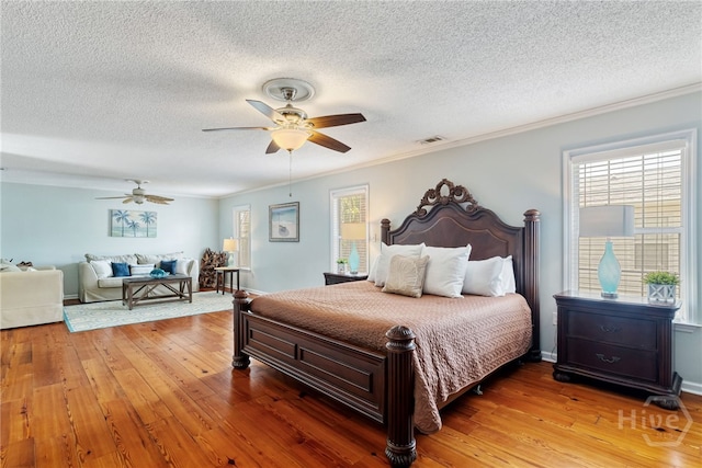 1406 Jones Ave, Tybee Island, GA 31328 - bedroom featuring multiple windows, crown molding, a textured ceiling, hardwood / wood-style flooring, and a ceiling fan