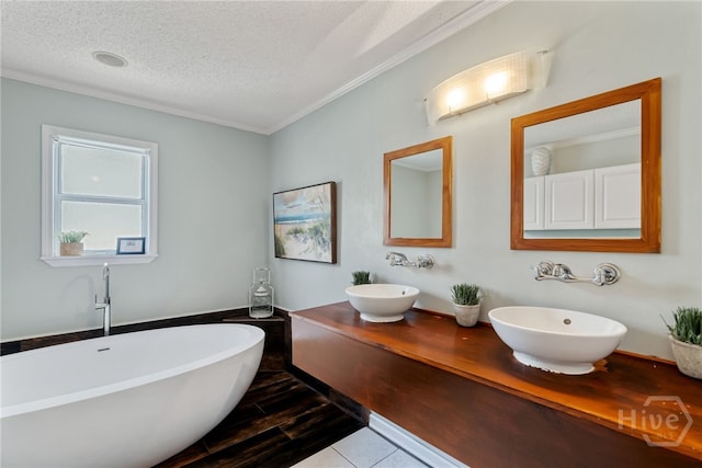 1406 Jones Ave, Tybee Island, GA 31328 - bathroom with crown molding, a textured ceiling, a freestanding bath, double vanity, and wood finished floors