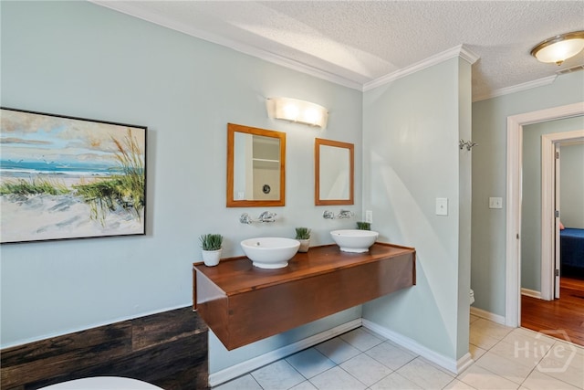 1406 Jones Ave, Tybee Island, GA 31328 - bathroom with toilet, ornamental molding, tile patterned flooring, double vanity, and a textured ceiling