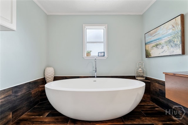 1406 Jones Ave, Tybee Island, GA 31328 - bathroom with a freestanding bath, wainscoting, crown molding, vanity, and wood finished floors