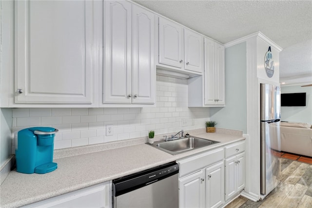 1406 Jones Ave, Tybee Island, GA 31328 - kitchen featuring appliances with stainless steel finishes, a sink, white cabinetry, a textured ceiling, and light countertops