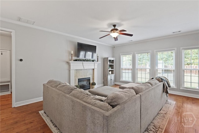 115 Meadowlands Dr, Rincon, GA 31326 - living room featuring baseboards, a ceiling fan, ornamental molding, a tiled fireplace, and wood finished floors