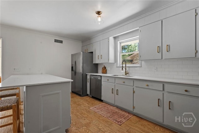 1939 Colonial Dr, Savannah, GA 31406 - kitchen featuring stainless steel appliances, a sink, ornamental molding, a peninsula, and tasteful backsplash