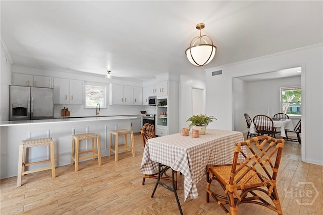 1939 Colonial Dr, Savannah, GA 31406 - dining room with light wood-type flooring and crown molding