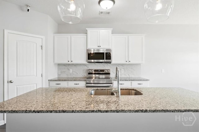 301 Akins Ranch Rd NE, Ludowici, GA 31316 - kitchen with stainless steel appliances, a sink, light stone counters, white cabinetry, and backsplash