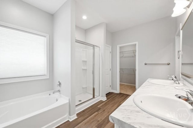 301 Akins Ranch Rd NE, Ludowici, GA 31316 - full bathroom featuring a shower stall, a garden tub, a walk in closet, wood finished floors, and double vanity