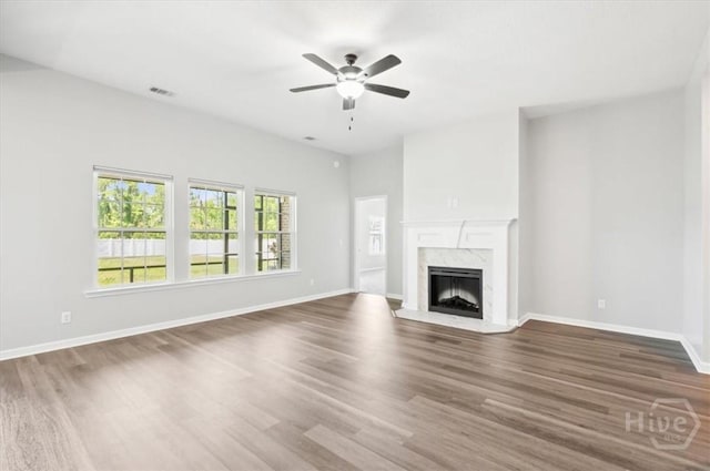 301 Akins Ranch Rd NE, Ludowici, GA 31316 - unfurnished living room with wood finished floors, a ceiling fan, a premium fireplace, and baseboards
