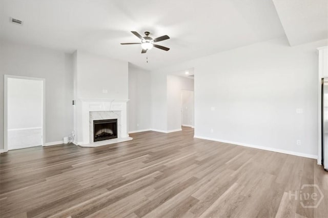 301 Akins Ranch Rd NE, Ludowici, GA 31316 - unfurnished living room featuring a ceiling fan, wood finished floors, a high end fireplace, and baseboards