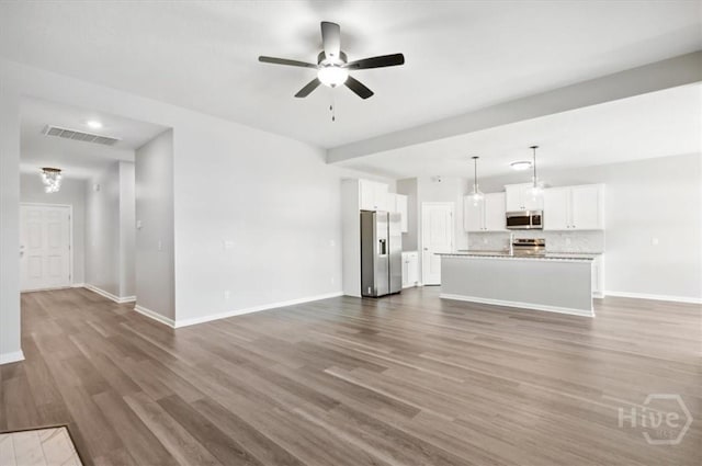 301 Akins Ranch Rd NE, Ludowici, GA 31316 - unfurnished living room with baseboards, ceiling fan, and wood finished floors